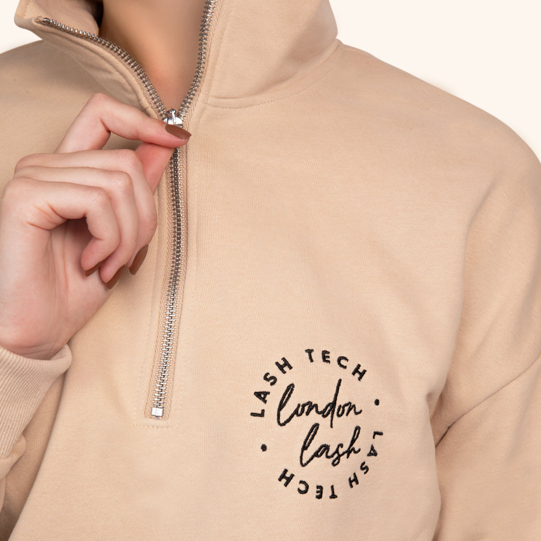 Le modèle affiche le hoodie de face, main sur la fermeture éclair, soulignant à la fois le confort et l&#39;élégance.